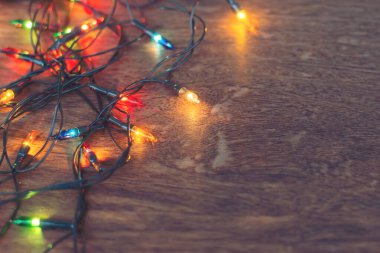 Koyu ahşap arka planda renkli noel ışıkları. Düz yatıyordu,