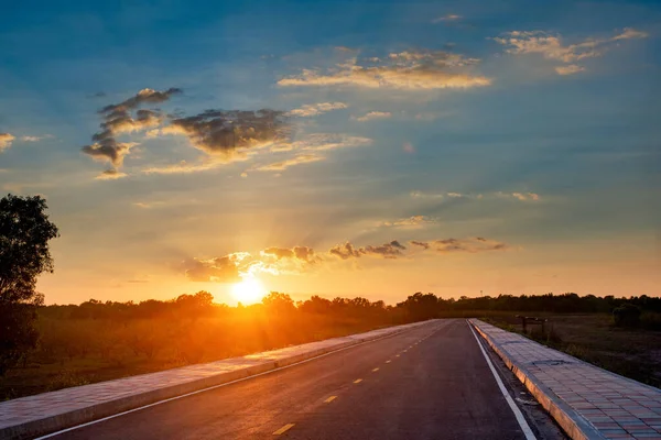 Camino de asfalto vacío cielo azul y puesta de sol backgroung con spac copia — Foto de Stock