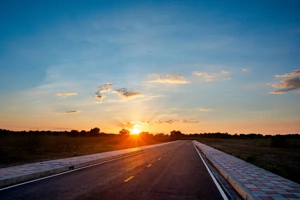 Camino de asfalto vacío cielo azul y puesta de sol backgroung con spac copia — Foto de Stock