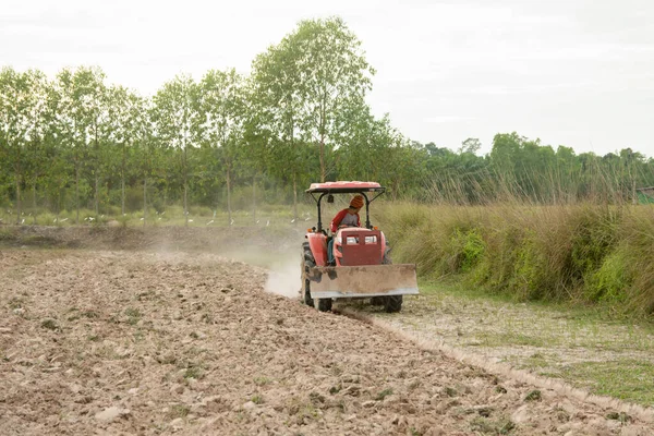 Tractor trabajando arados un campo en la granja para la plantación —  Fotos de Stock