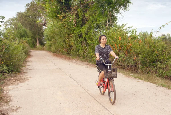 Kvinna ridning cykel koppla av på en landsväg. — Stockfoto