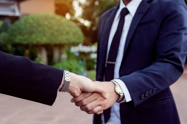 Businessman and woman shake hands after a business meeting