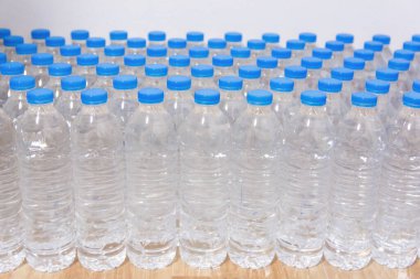 Sıra sıra su şişeleri. Mavi şapkalı şişeler içme suyu için.