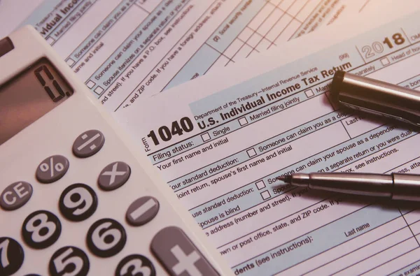 Temporada de impuestos. calculadora, pluma en 1040 fondo de formulario de impuestos — Foto de Stock