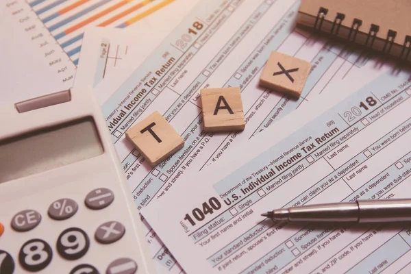 Tax with wooden alphabet blocks, calculator, pen on 1040 tax for — Stock Photo, Image