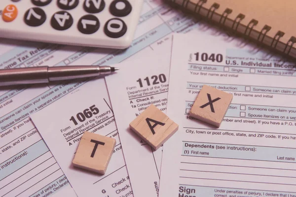 Tax with wooden alphabet blocks, calculator, pen on 1040 tax for — Stock Photo, Image