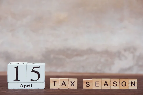 Tax season with 15th April. Calendar wooden block cube with numb