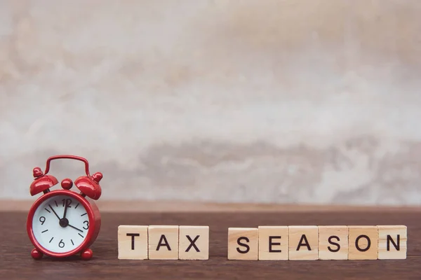 Daňová sezóna s dřevěnými abecedními bloky a červenými budíky, na T — Stock fotografie