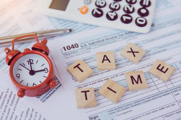 Tax time with wooden alphabet blocks, red alarm clock, calculato — Stock Photo, Image