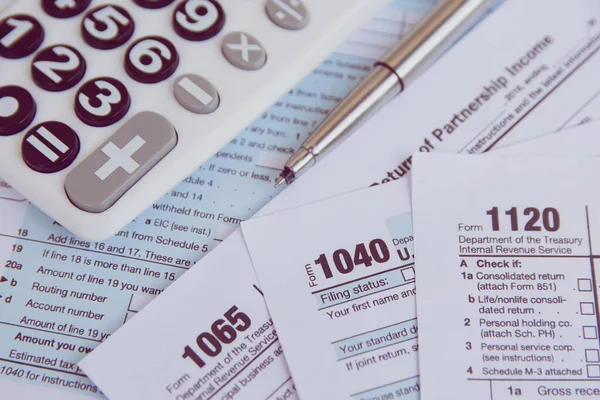 Temporada de impuestos. calculadora, pluma sobre fondo de formulario de impuestos de EE.UU. — Foto de Stock