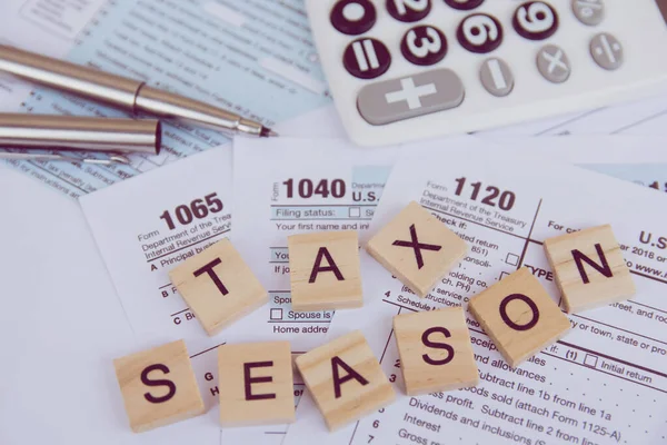 Tax season with wooden alphabet blocks, calculator, pen on 1040 — Stock Photo, Image