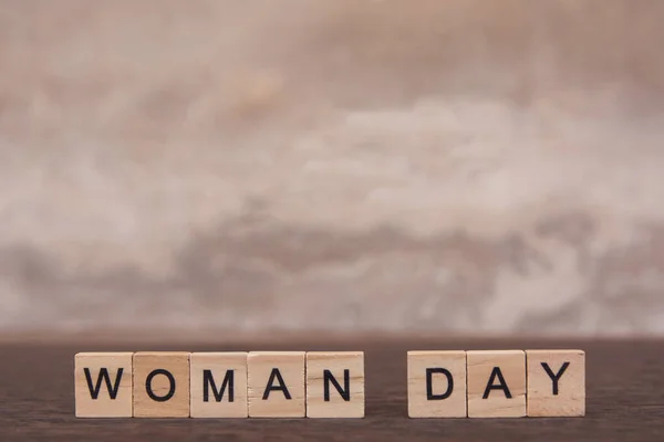 Woman day text with alphabet wooden block cube on table dark pla — Stock Photo, Image