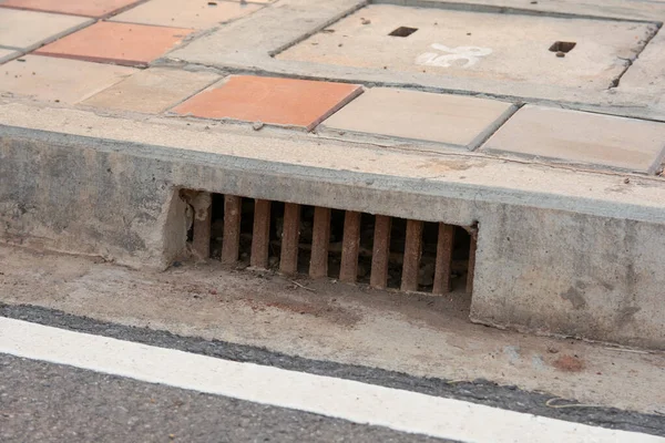 Sewer drain along road in city — Stock Photo, Image