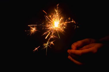 Yanan maytap tutan bir kadın.