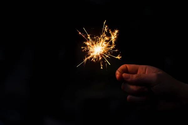 Mulher mão segurando um sparkler ardente — Fotografia de Stock