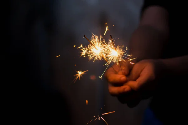 Mulher mão segurando um sparkler ardente — Fotografia de Stock