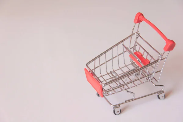 Carrito de supermercado de compras rojo sobre fondo blanco con spac de copia — Foto de Stock
