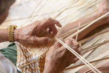 Kıdemli adam elleriyle bambu örüyor..