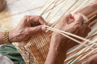 Kıdemli adam elleriyle bambu örüyor..