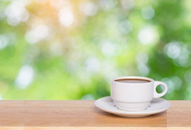 Boş ahşap masa üstü ve kahve fincanı ile arka planı bulanıklaştırır 
