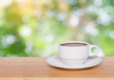 Boş ahşap masa üstü ve kahve fincanı ile arka planı bulanıklaştırır 