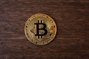 Koyu ahşap arka planda Bitcoin altın sikke