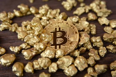 Koyu ahşap arka planda altın külçeler üzerinde altın bitcoin
