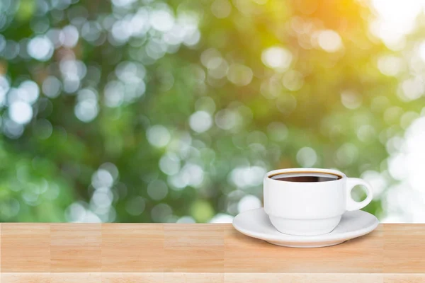 Leere Holzplatte und Kaffeetasse verschwimmen Natur Hintergrund mit — Stockfoto