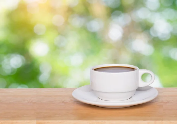 Leere Holzplatte und Kaffeetasse verschwimmen Natur Hintergrund mit — Stockfoto