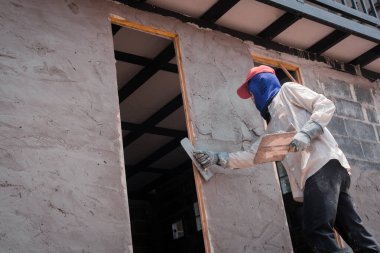 Construction workers plastering building wall using cement plast clipart