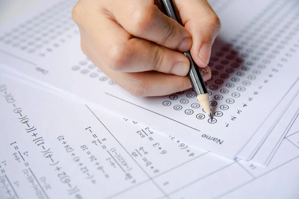 Estudiantes mano celebración lápiz escritura elección seleccionada en respuesta s — Foto de Stock