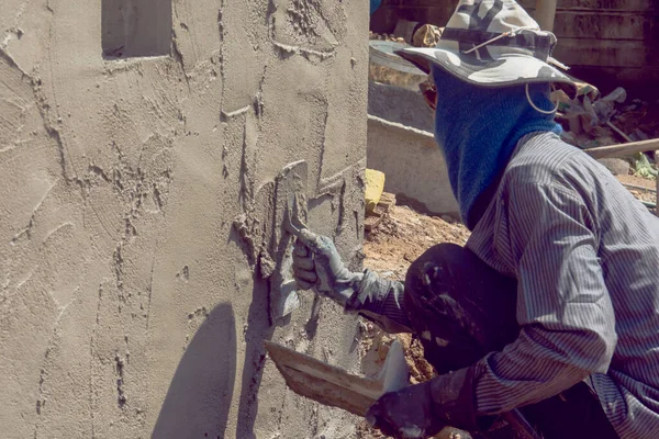 Trabalhadores da construção civil que rebocam a parede do edifício usando o emplastro do cimento — Fotografia de Stock