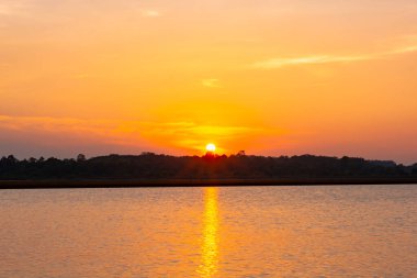 Gün batımı yansıma gölü. Bulutların ardında güzel bir gün batımı
