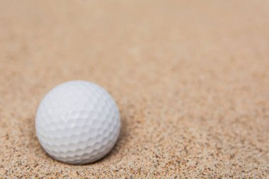 Kum sığınağındaki beyaz golf topunun seçici odağı