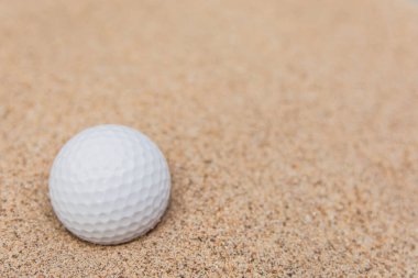Kum sığınağındaki beyaz golf topunun seçici odağı