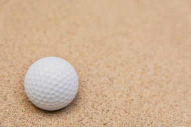 Kum sığınağındaki beyaz golf topunun seçici odağı