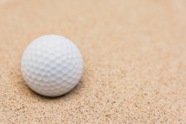 Kum sığınağındaki beyaz golf topunun seçici odağı