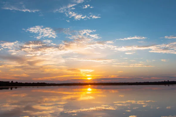 Lagoa de reflexão do pôr do sol. belo pôr do sol atrás das nuvens e — Fotografia de Stock