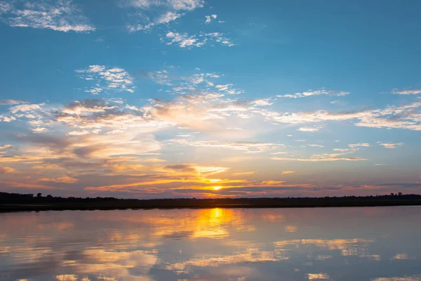 Lagoa de reflexão do pôr do sol. belo pôr do sol atrás das nuvens e — Fotografia de Stock