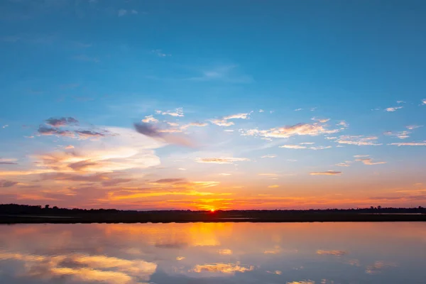 Lagoa de reflexão do pôr do sol. belo pôr do sol atrás das nuvens e — Fotografia de Stock