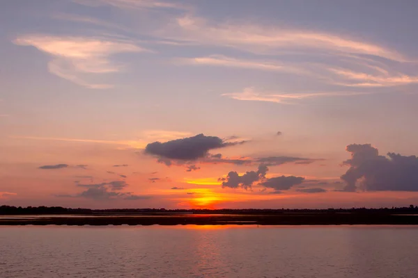 Lagoa de reflexão do pôr do sol. belo pôr do sol atrás das nuvens e — Fotografia de Stock