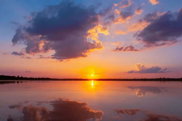 Lagoa de reflexão do pôr do sol. belo pôr do sol atrás das nuvens e — Fotografia de Stock