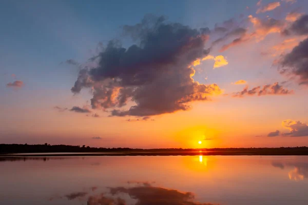 Laguna de reflexión al atardecer. hermosa puesta de sol detrás de las nubes y — Foto de Stock