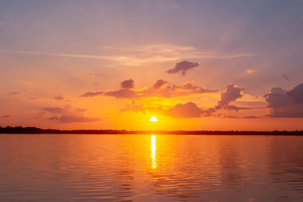 Lagoa de reflexão do pôr do sol. belo pôr do sol atrás das nuvens e — Fotografia de Stock