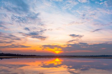 Gün batımı yansıma gölü. Bulutların ardında güzel bir gün batımı