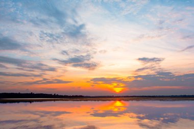Gün batımı yansıma gölü. Bulutların ardında güzel bir gün batımı