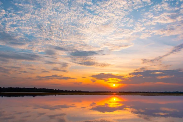 Laguna de reflexión al atardecer. hermosa puesta de sol detrás de las nubes y — Foto de Stock