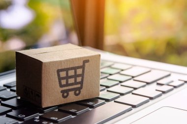 İnternetten alışveriş, kağıt kutular ya da klavyede alışveriş arabası logosu olan bir paket. İnternet üzerinden alışveriş hizmeti sunuyor.