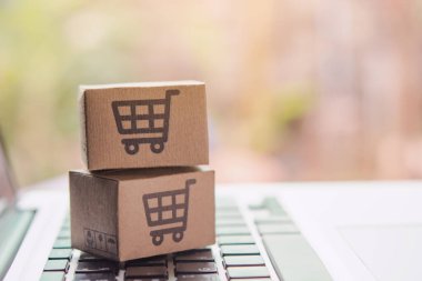 İnternetten alışveriş, kağıt kutular ya da klavyede alışveriş arabası logosu olan bir paket. İnternet üzerinden alışveriş hizmeti sunuyor.
