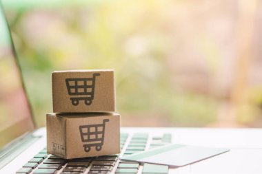 İnternetten alışveriş, kağıt kutular ya da klavyede alışveriş arabası logosu ve kredi kartı olan bir paket. İnternet üzerinden alışveriş hizmeti sunuyor..